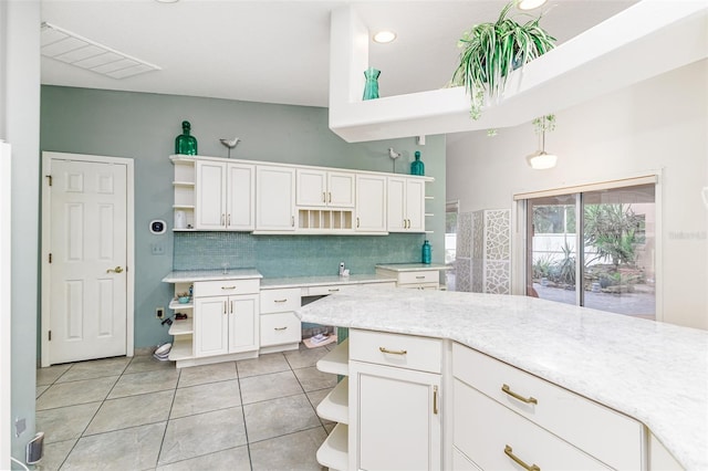 kitchen featuring pendant lighting, decorative backsplash, light stone countertops, light tile patterned flooring, and white cabinetry