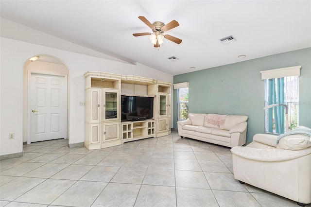 living room with ceiling fan, light tile patterned floors, and vaulted ceiling