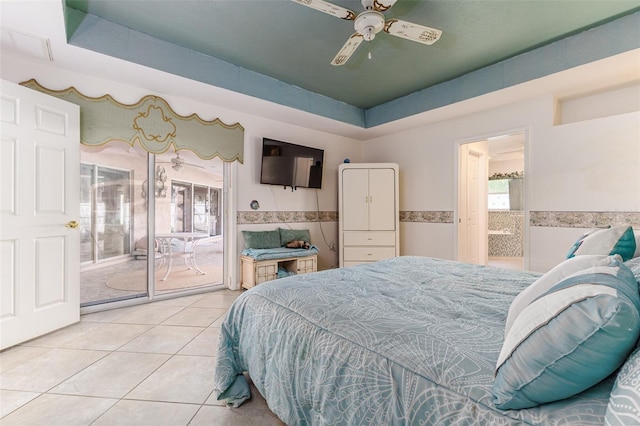 bedroom featuring access to exterior, ceiling fan, a tray ceiling, light tile patterned flooring, and tile walls