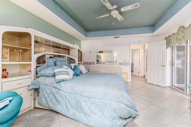 bedroom featuring light tile patterned floors, a raised ceiling, and ceiling fan