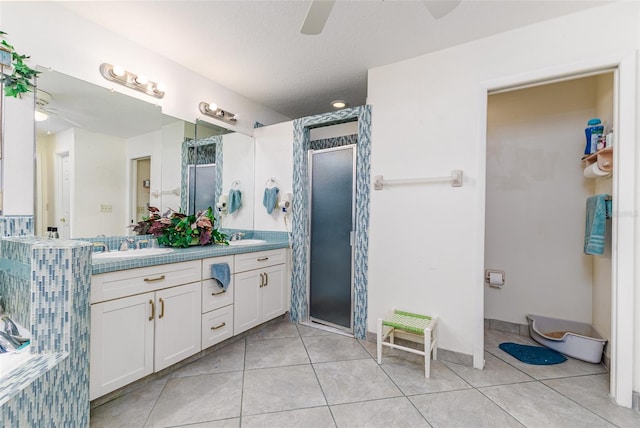 bathroom with ceiling fan, tile patterned flooring, a textured ceiling, an enclosed shower, and vanity