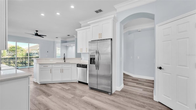 kitchen featuring white cabinetry, sink, ceiling fan, kitchen peninsula, and appliances with stainless steel finishes