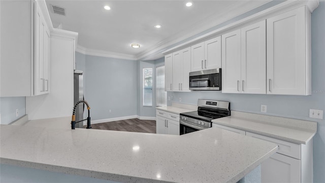 kitchen with white cabinets, light stone counters, crown molding, and stainless steel appliances