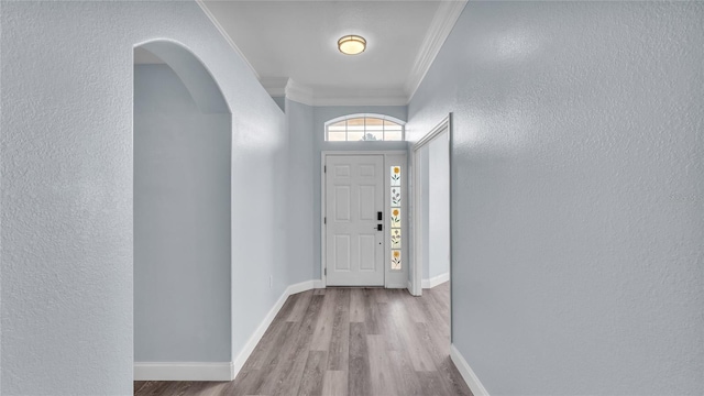 foyer featuring light wood-type flooring and crown molding