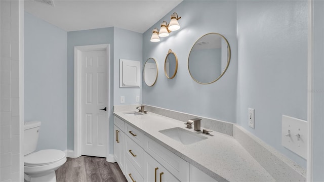 bathroom with wood-type flooring, vanity, and toilet