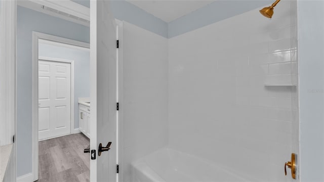 bathroom featuring vanity, wood-type flooring, and tub / shower combination