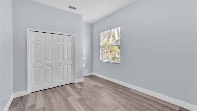 unfurnished bedroom with light hardwood / wood-style floors and a closet