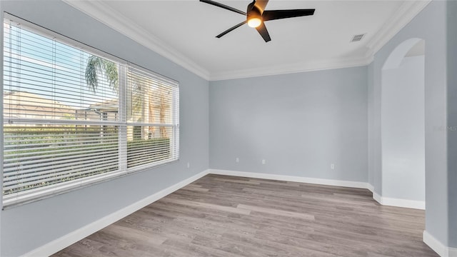 empty room with ceiling fan, light wood-type flooring, and ornamental molding