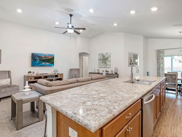 kitchen with dishwasher, sink, light hardwood / wood-style flooring, vaulted ceiling, and an island with sink