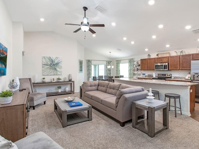 carpeted living room with sink, ceiling fan with notable chandelier, and lofted ceiling