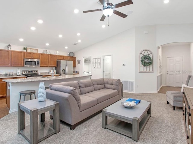 carpeted living room featuring vaulted ceiling and ceiling fan