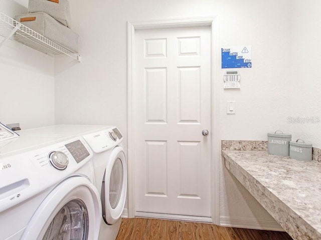 clothes washing area featuring independent washer and dryer and light hardwood / wood-style flooring