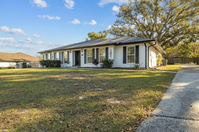 ranch-style home featuring a front lawn and central AC unit