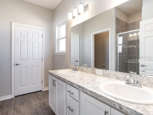 bathroom with vanity, hardwood / wood-style flooring, and a shower with door