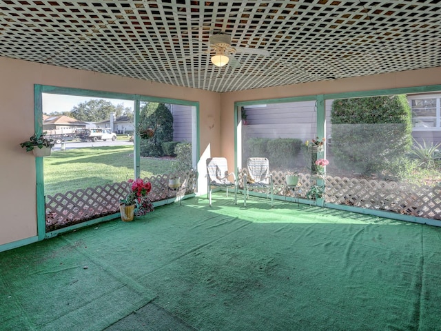 unfurnished sunroom with ceiling fan