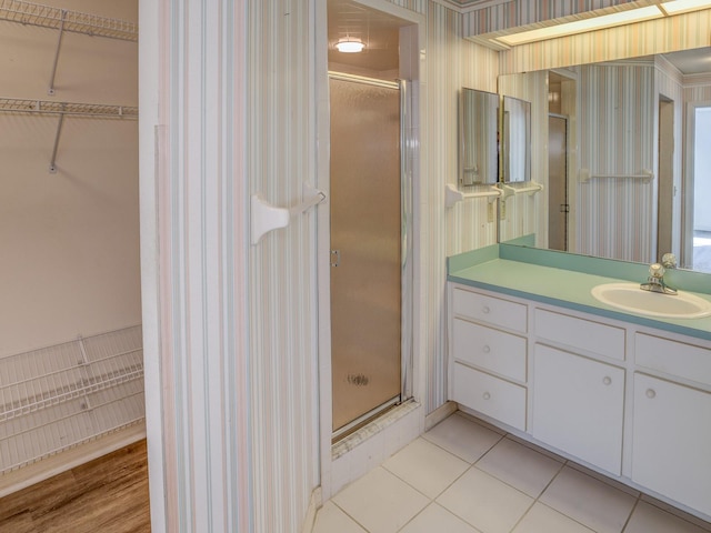 bathroom with tile patterned flooring, vanity, and a shower with door