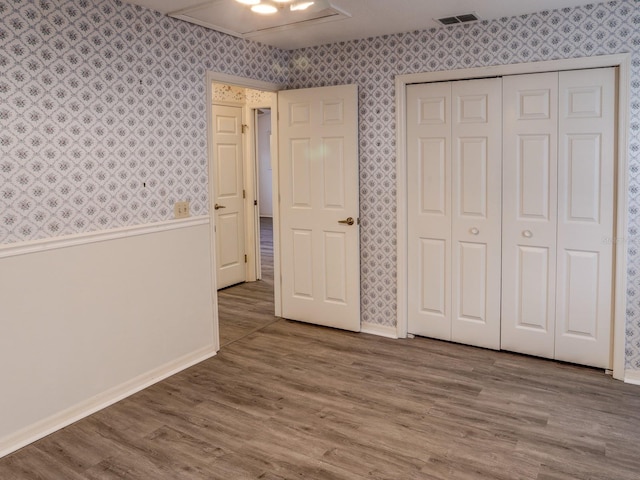 unfurnished bedroom with wood-type flooring and a closet