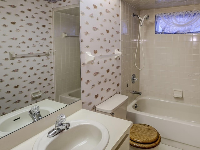 full bathroom with toilet, vanity, and tiled shower / bath