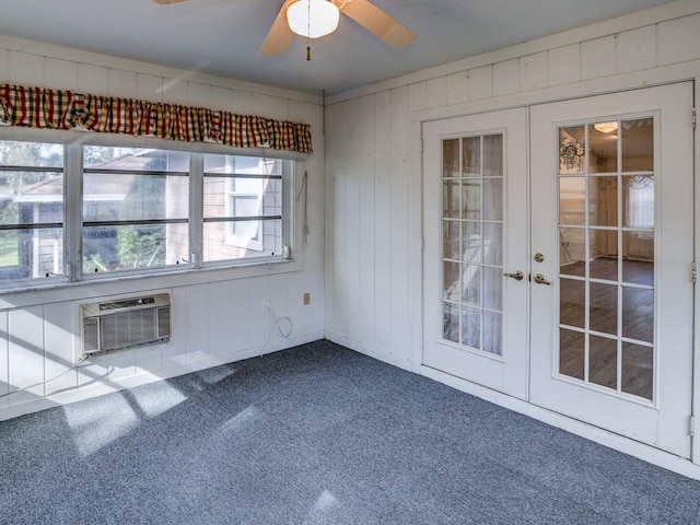 carpeted spare room with ceiling fan, an AC wall unit, and french doors