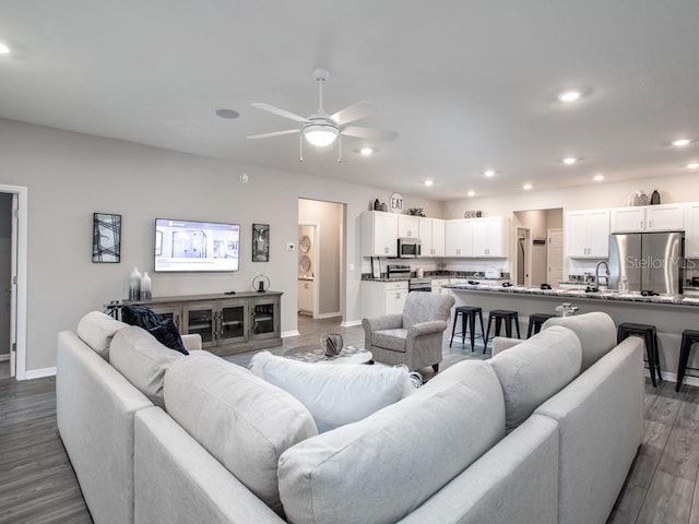 living room with dark hardwood / wood-style floors and ceiling fan