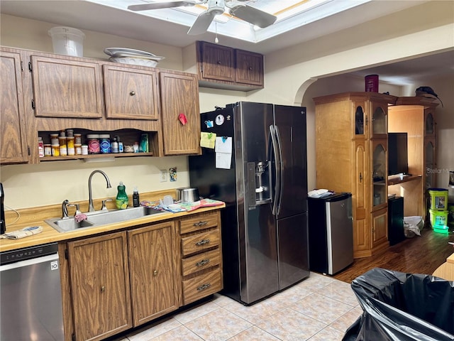 kitchen with light tile patterned floors, ceiling fan, stainless steel appliances, a sink, and light countertops