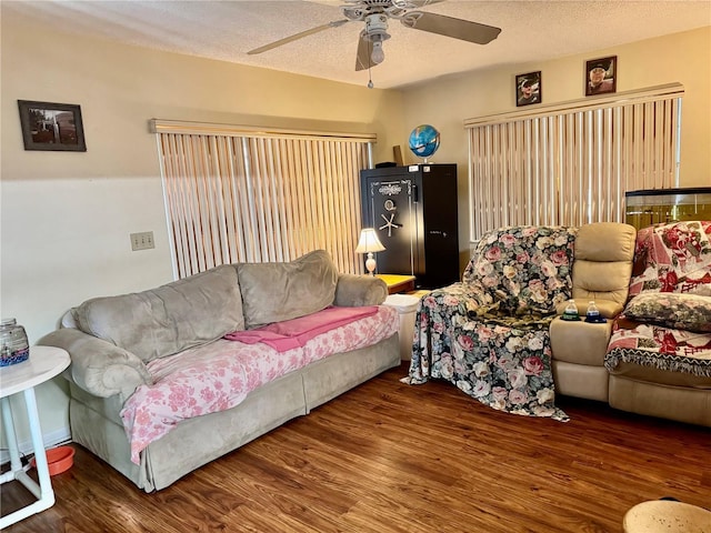 living room featuring ceiling fan, a textured ceiling, and wood finished floors