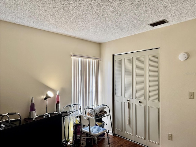 office area featuring a textured ceiling, dark wood-style flooring, and visible vents