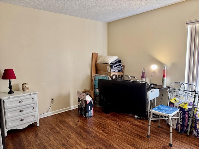 home office with a textured ceiling, baseboards, and wood finished floors