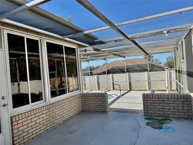 view of patio with a lanai, fence, and a fenced in pool