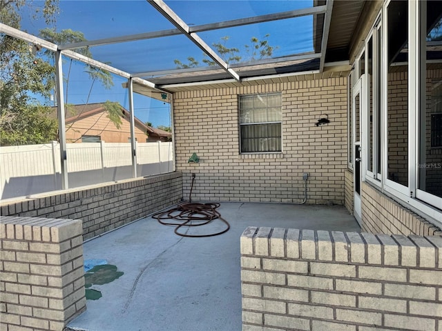 view of patio / terrace with a lanai and fence