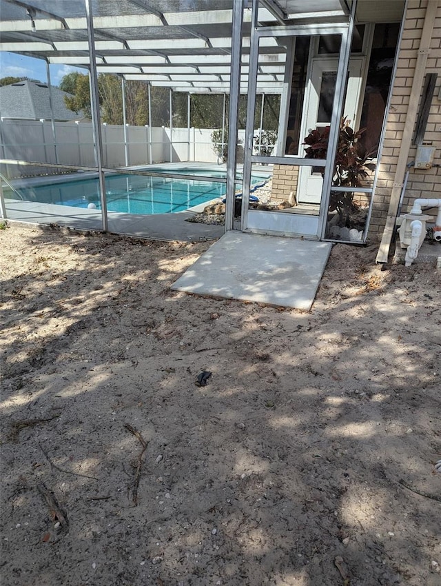 view of swimming pool featuring a patio, fence, a fenced in pool, and a lanai