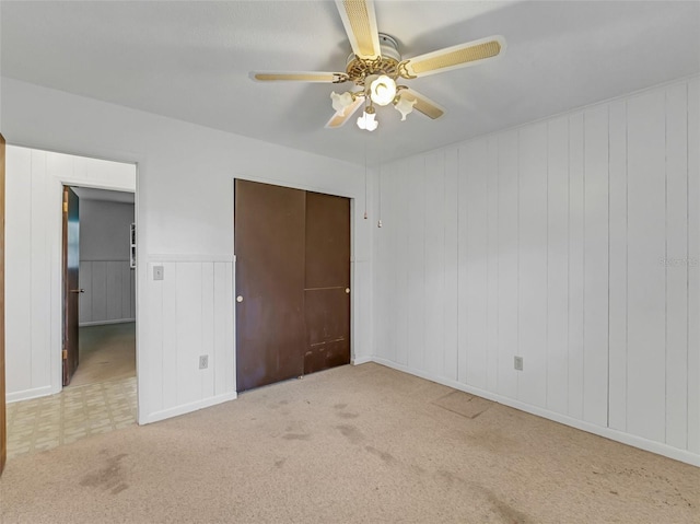 unfurnished bedroom with ceiling fan, a closet, and light colored carpet