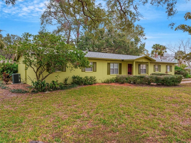 ranch-style home featuring a front lawn and cooling unit