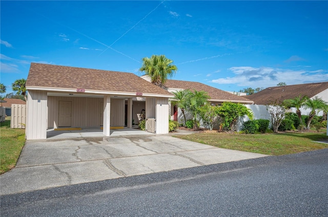 single story home featuring a front yard and a carport