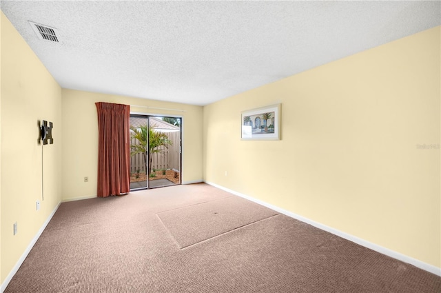 carpeted empty room featuring a textured ceiling