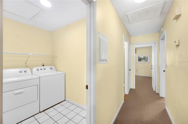 clothes washing area featuring washer and clothes dryer, light tile patterned flooring, and a textured ceiling