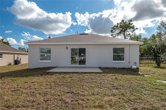 rear view of property with central AC, a patio area, and a lawn