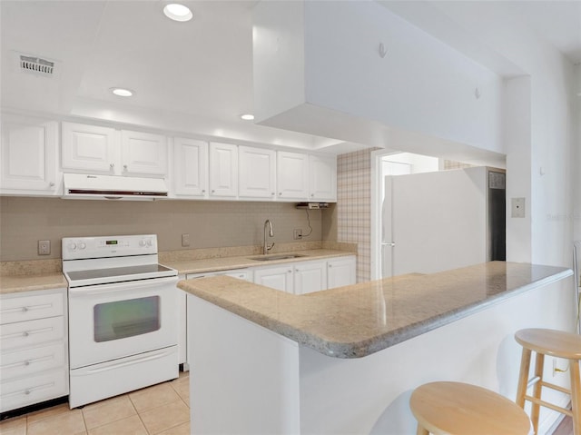 kitchen with a breakfast bar, white appliances, sink, exhaust hood, and white cabinetry