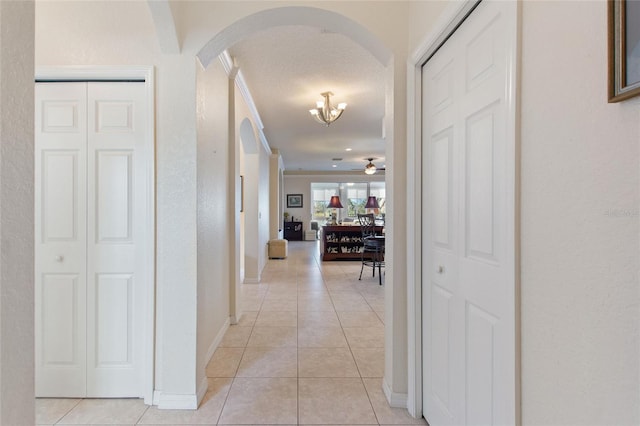 hallway featuring light tile patterned floors and a textured ceiling