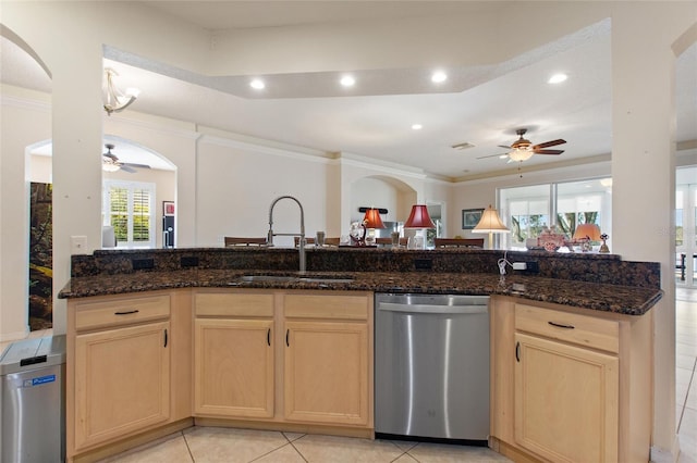 kitchen featuring crown molding, sink, stainless steel dishwasher, and dark stone counters