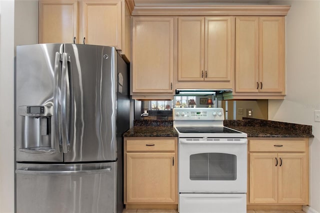 kitchen featuring dark stone countertops, light brown cabinetry, white range with electric stovetop, and stainless steel fridge with ice dispenser