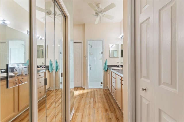 bathroom featuring vanity, hardwood / wood-style floors, ceiling fan, and a shower with shower door