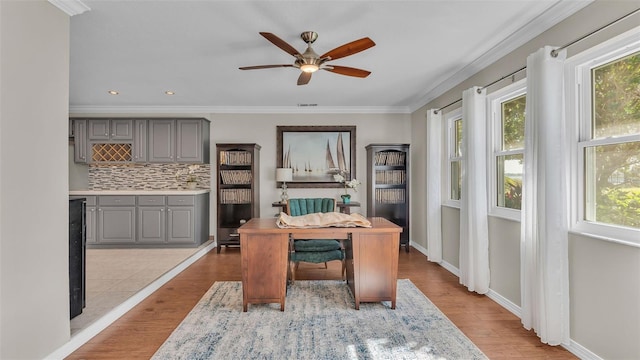 office space with crown molding, ceiling fan, and light hardwood / wood-style flooring