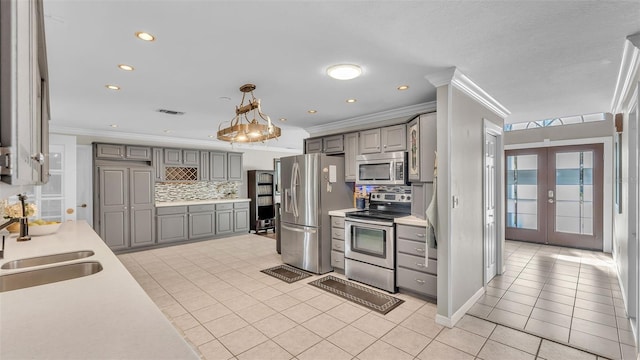 kitchen featuring gray cabinetry, sink, decorative light fixtures, and appliances with stainless steel finishes