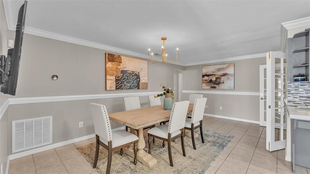 dining room with crown molding, an inviting chandelier, and light tile patterned floors