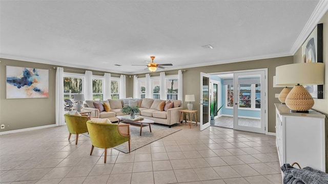 tiled living room with ornamental molding, ceiling fan, and french doors