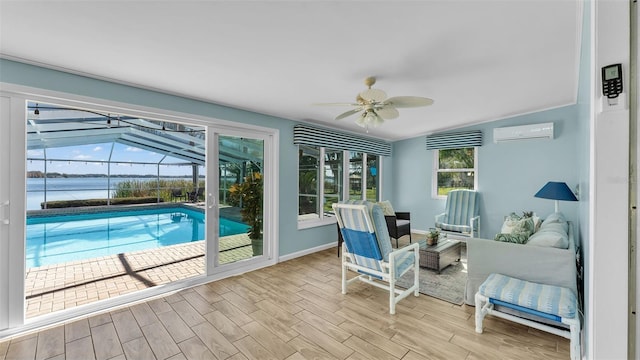 sunroom / solarium featuring a water view, ceiling fan, vaulted ceiling, and a wall unit AC