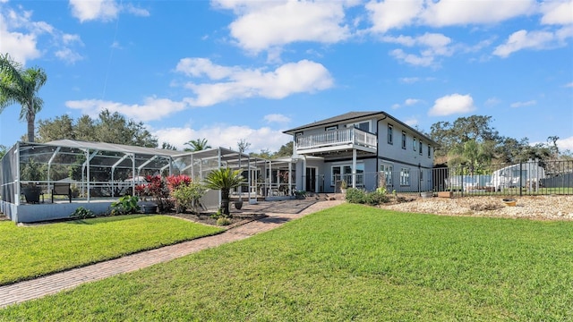 back of house featuring glass enclosure and a lawn