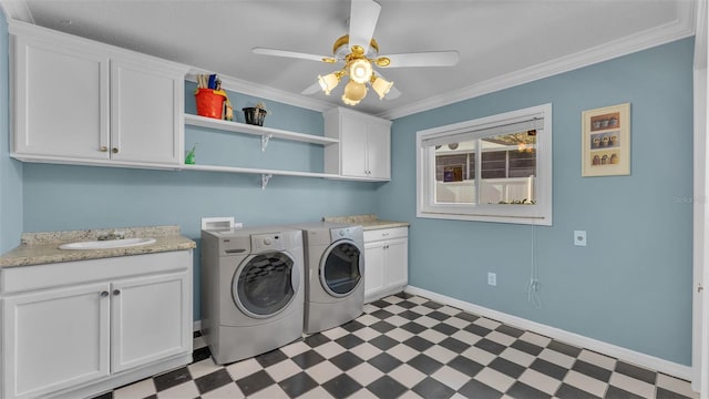 washroom with sink, crown molding, ceiling fan, cabinets, and independent washer and dryer