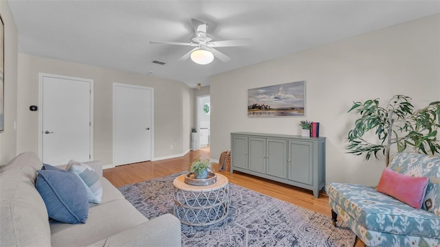 living room with ceiling fan and light hardwood / wood-style flooring